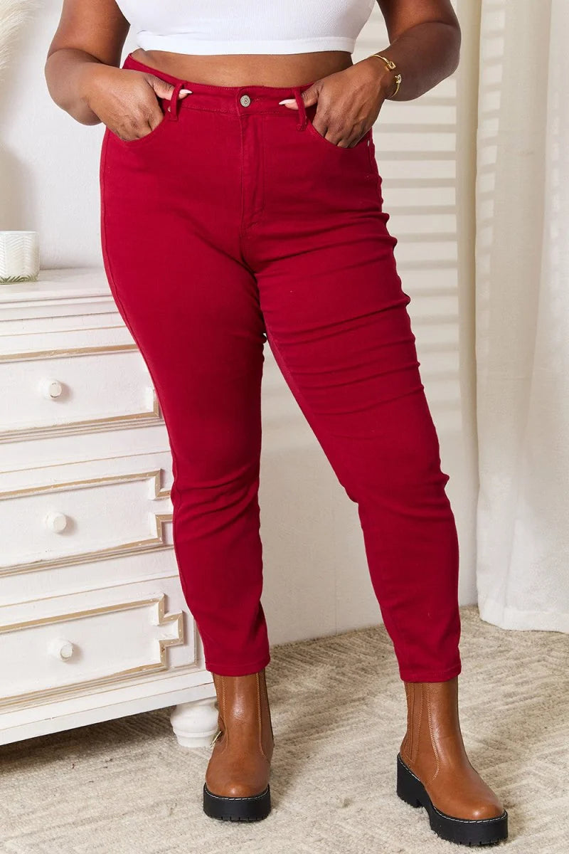 Red, high-waisted jeans with pockets and brown boots, on model.