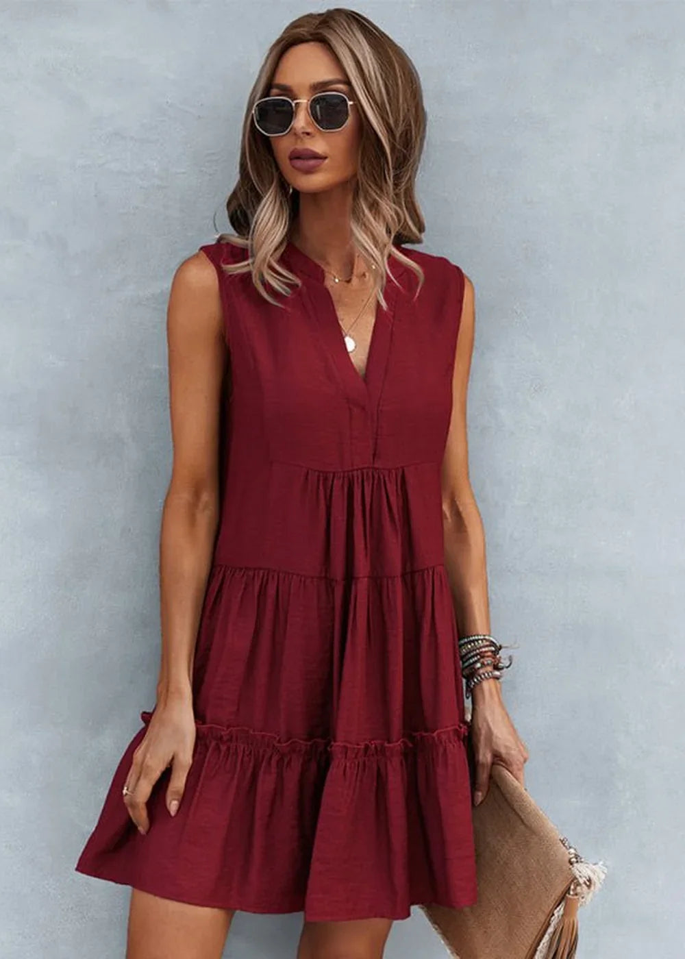 Maroon tiered sleeveless V-neck dress with ruffled hem, worn by a model with sunglasses and bracelets.
