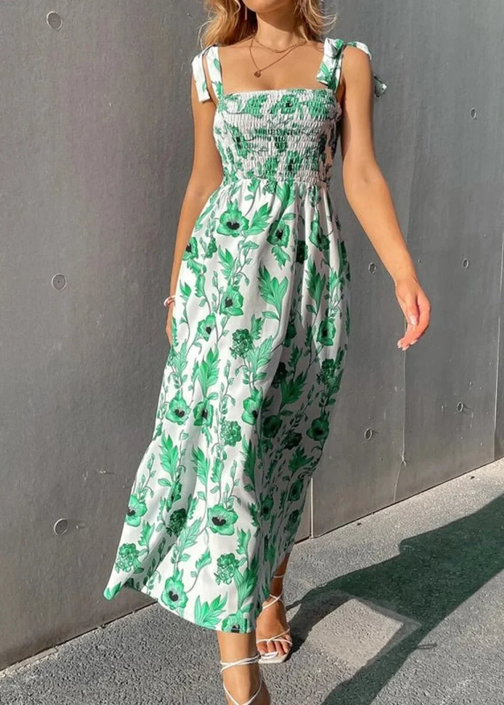 White and green floral print smocked midi dress with tie straps on a model.