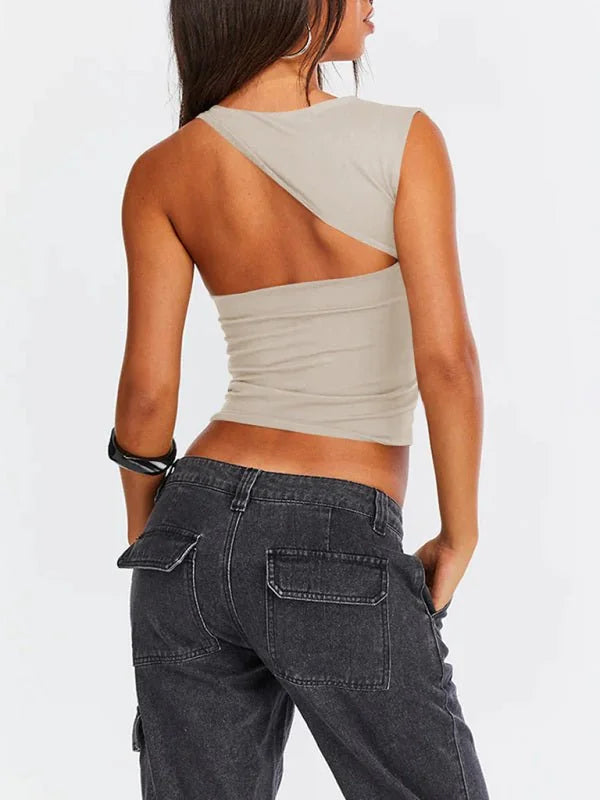 Tan one-shoulder crop top with a cut-out back, shown with dark wash cargo jeans.