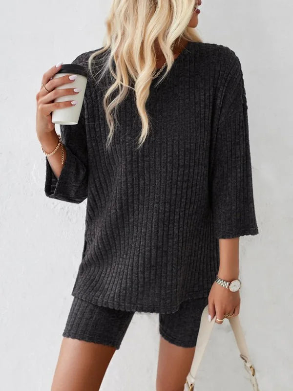 Dark gray ribbed knit loungewear set on a model, with a relaxed-fit top and bike shorts.