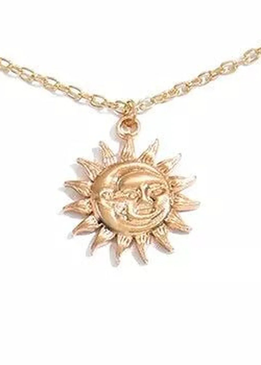 Gold-plated sun and moon pendant necklace with intricate facial details on a white background.