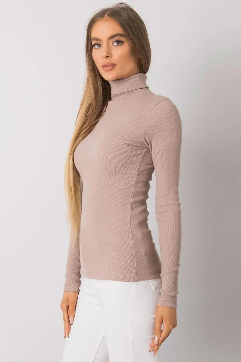 Fitted taupe ribbed turtleneck long-sleeve top on a model.