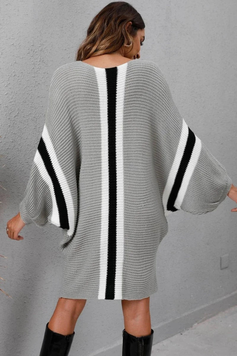 Grey knit sweater dress with vertical black and white stripes, long dolman sleeves, on model.