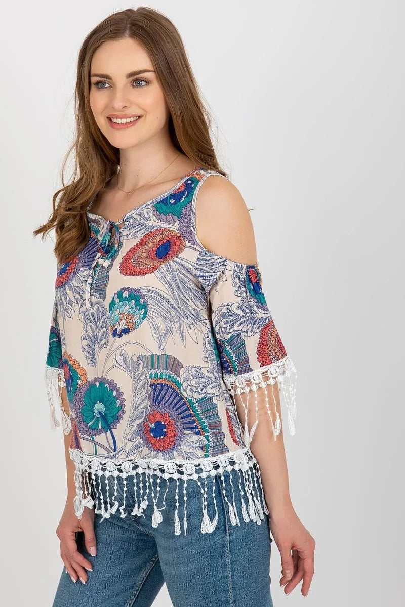 Beige cold-shoulder top with a colorful floral print, lace trim, and tie neckline.