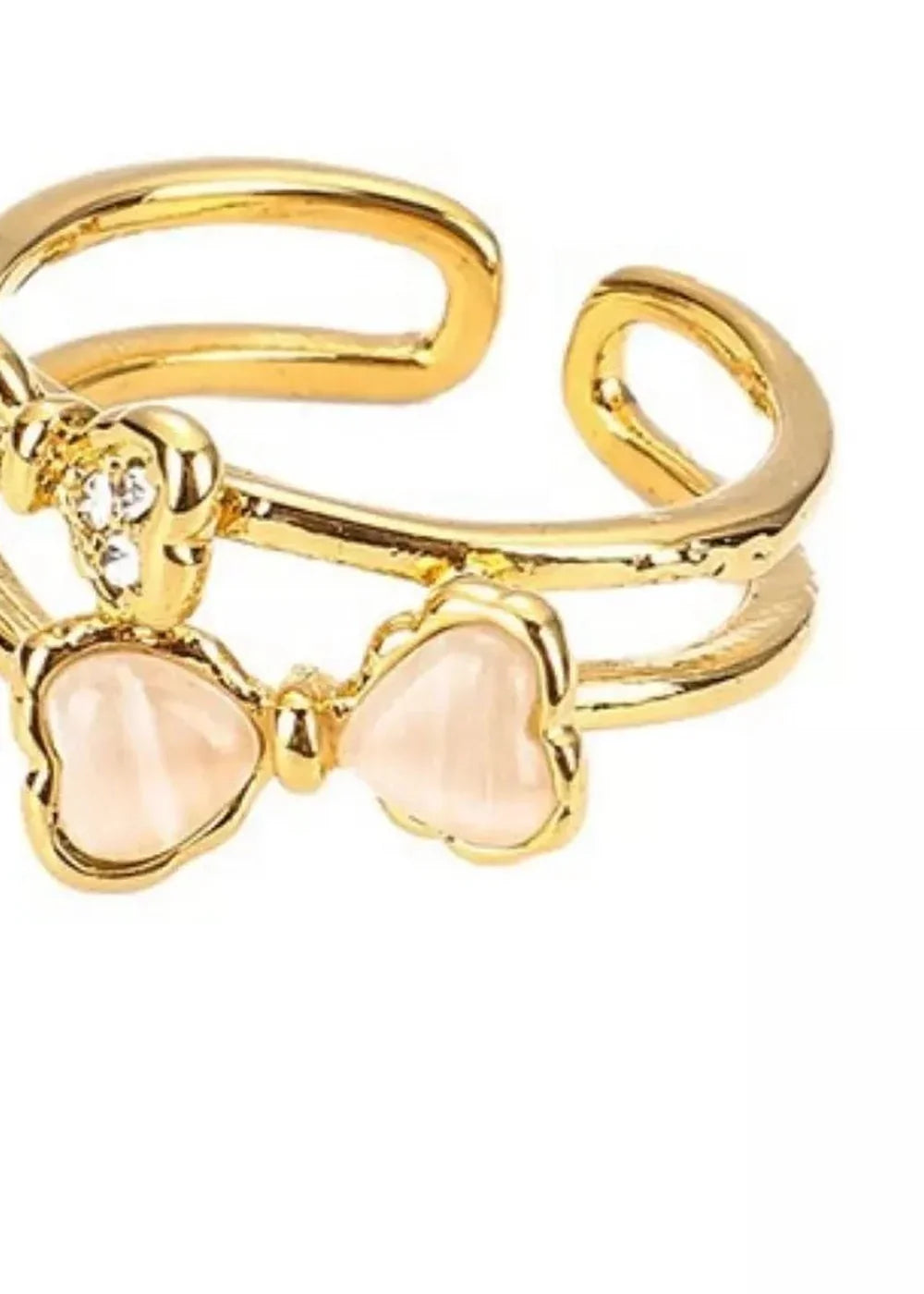 Gold ring with double band, featuring two bow shapes, one with rhinestones and the other with a pale pink gem.