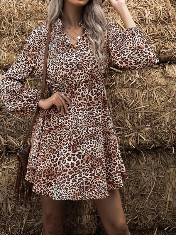 A flowy mini dress with a brown and black leopard print, long balloon sleeves, and a ruffled V-neck.
