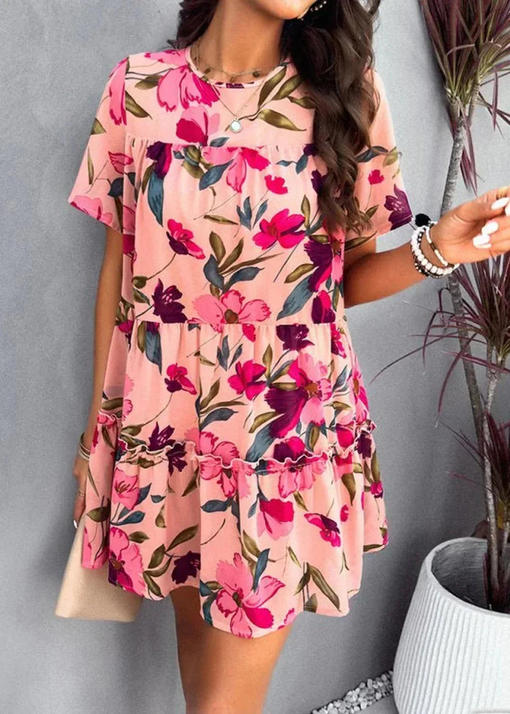 Pink floral print short-sleeve tiered mini dress with ruffled hem.