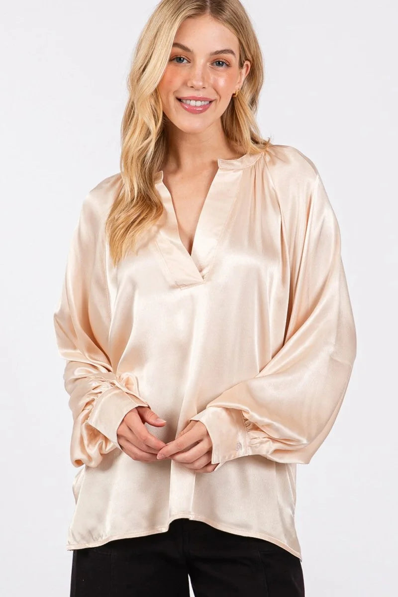 Satin-like champagne V-neck blouse with relaxed fit and gathered cuffs.