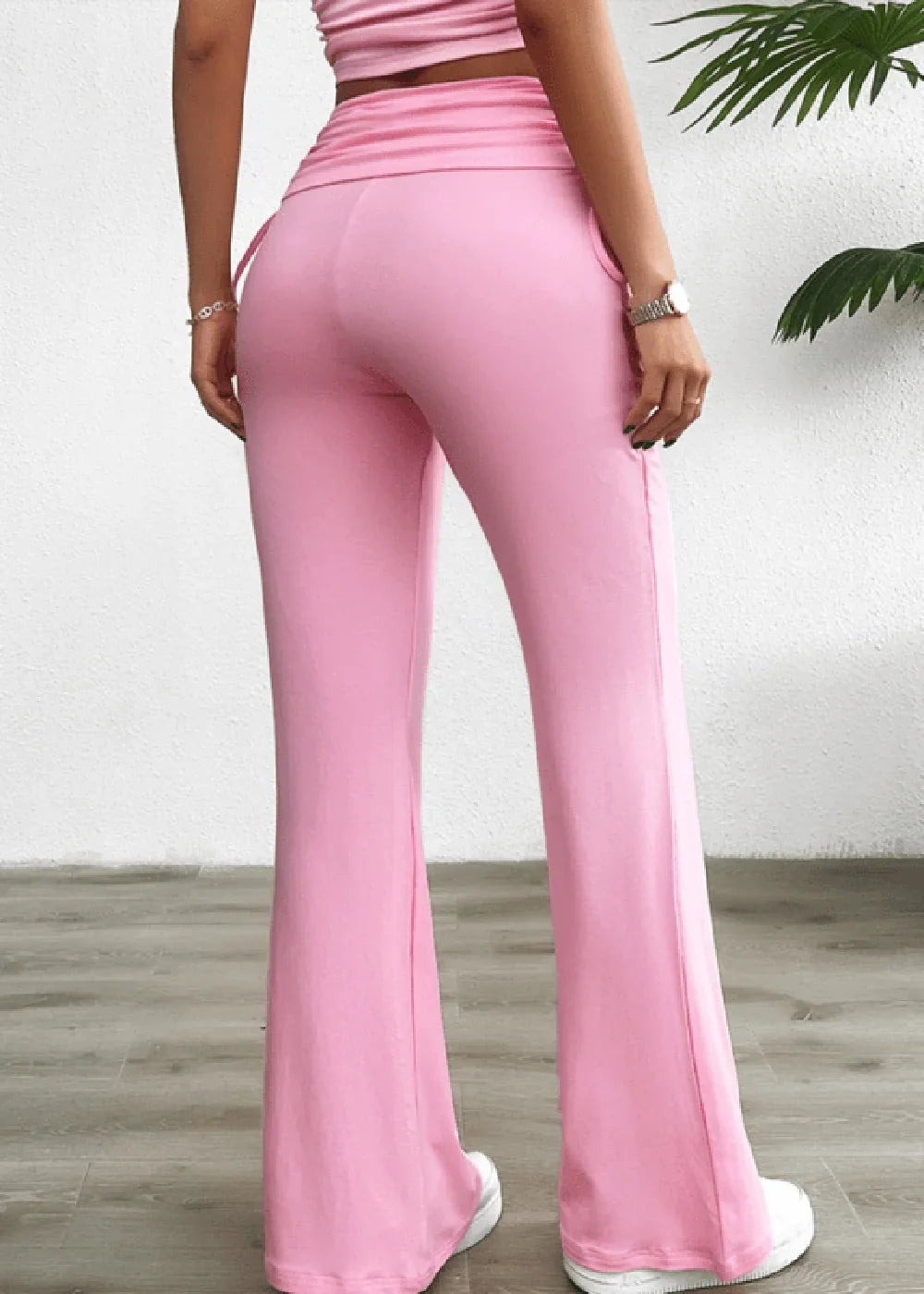 Pink flared pants with ruched waistband and side pockets, shown from the back.