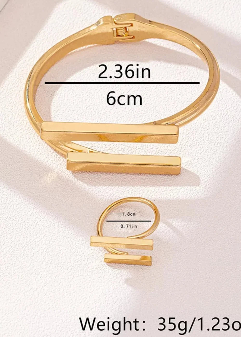 Gold-toned cuff bracelet and ring with bar accents, with size and weight details.