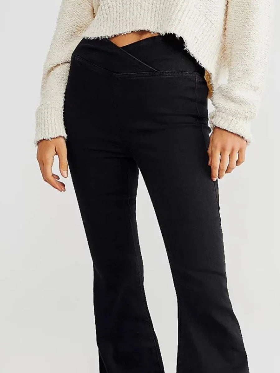 Black flared jeans with a unique V-shaped waist detail, shown on a model.