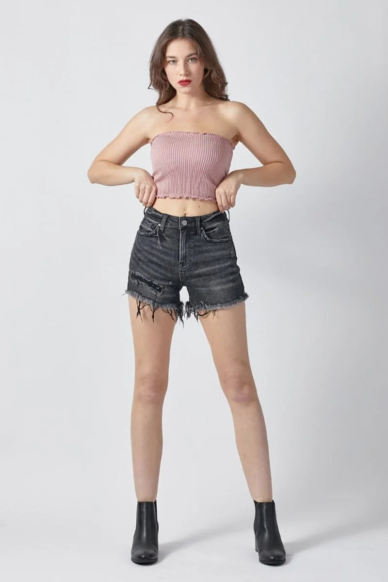 Distressed charcoal denim shorts with frayed hem and ripped details, on model.