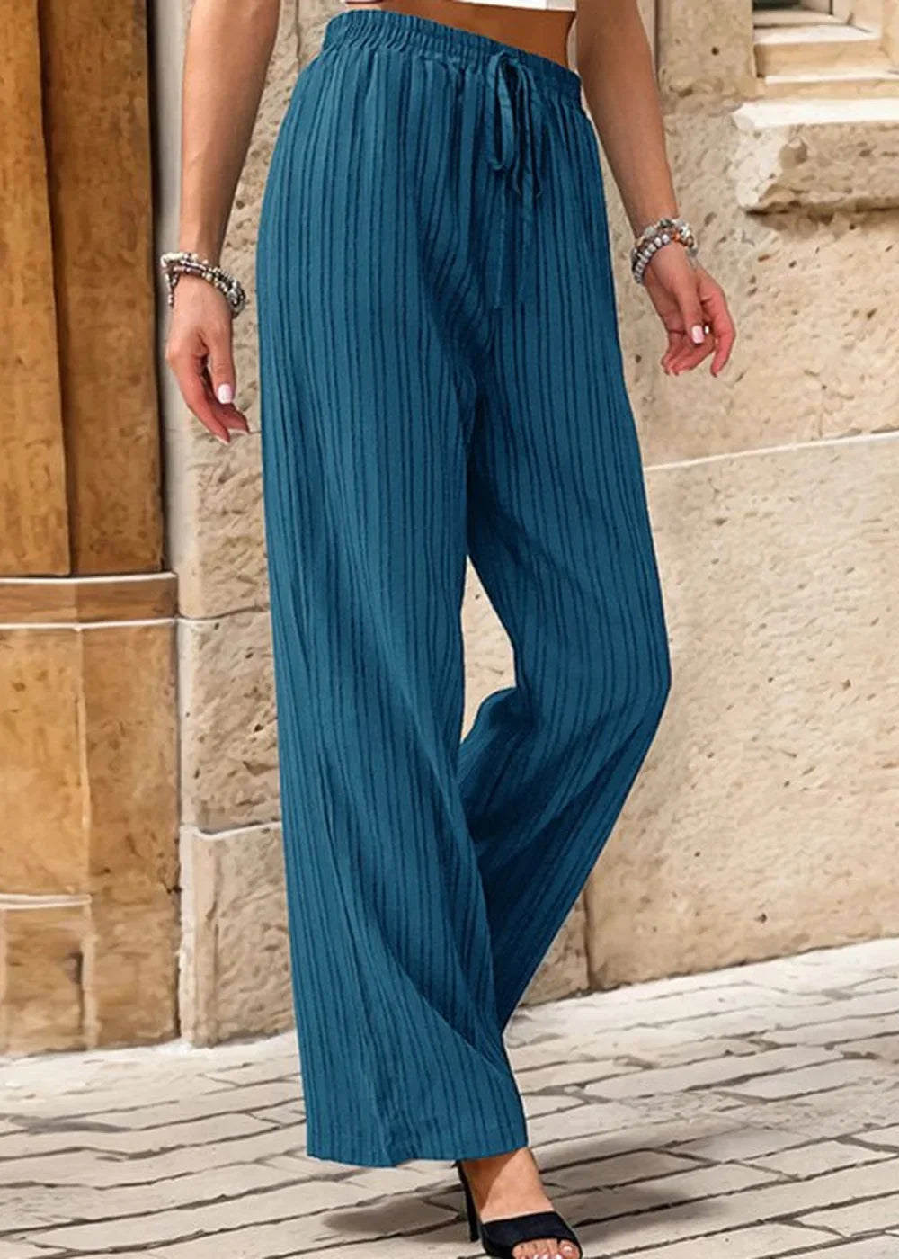 Teal textured wide-leg pants with a drawstring waist, shown on a model.