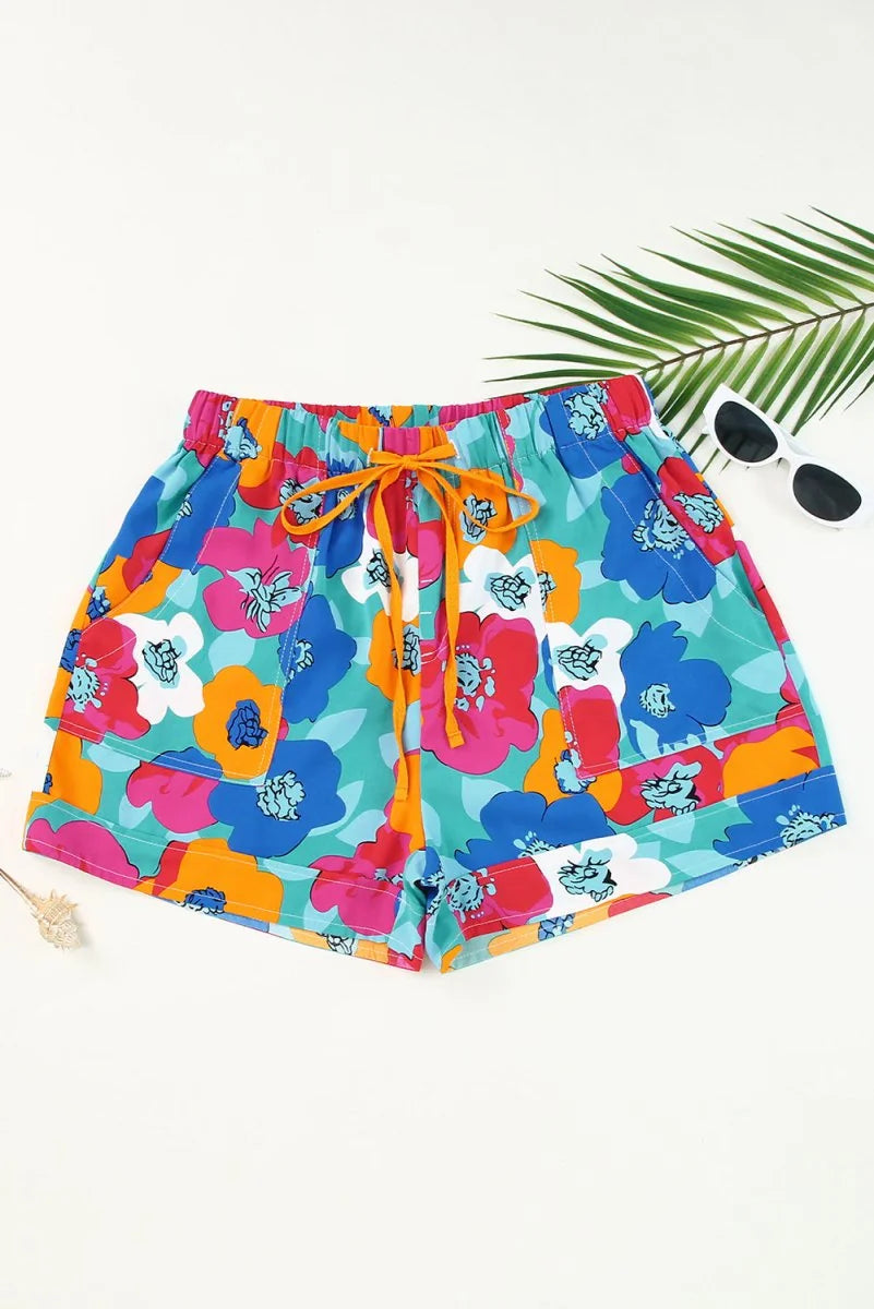 Turquoise shorts with a vibrant, large floral print in pink, blue, and orange, featuring a drawstring waist.