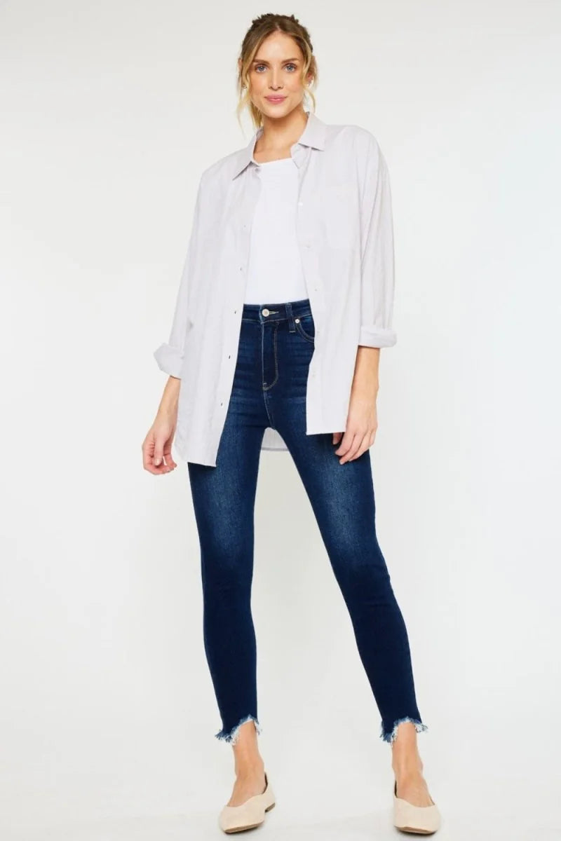 Dark wash, slightly stretchy skinny jeans with a frayed hem on a model.
