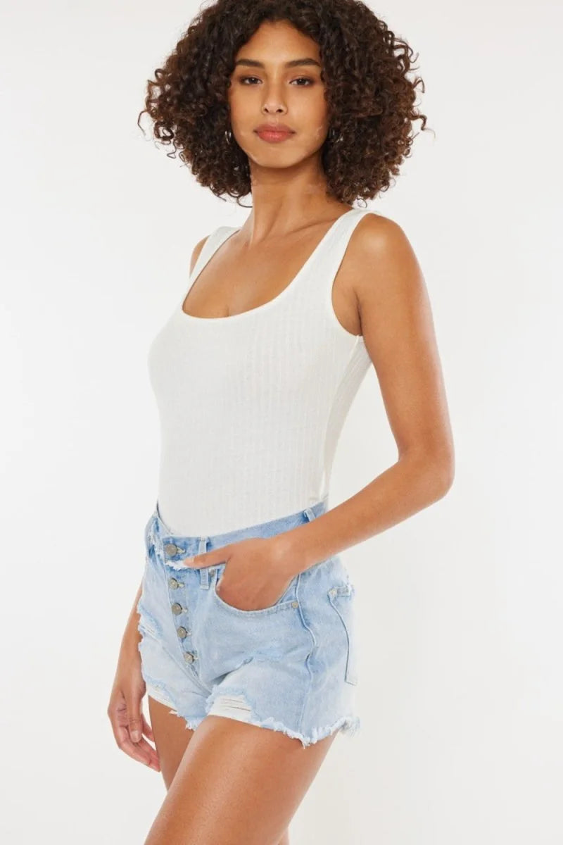 Light wash denim shorts with button fly and frayed hem on a model.