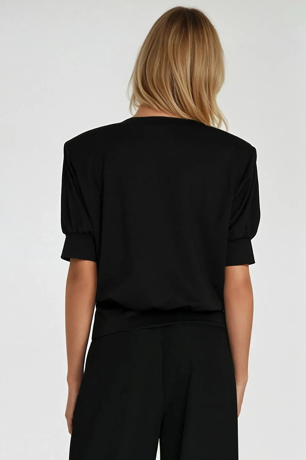 Black oversized top with padded shoulders and puffed short sleeves, shown from the back.