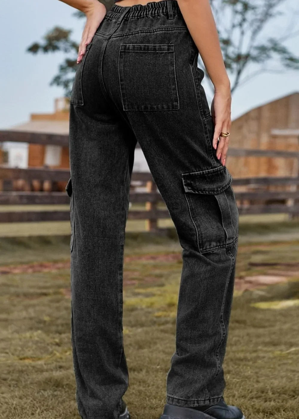 Close-up of dark wash denim cargo pants with multiple pockets and elastic waistband.