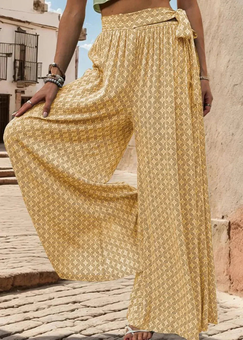 Yellow wide-leg pants with a geometric print and a tie-waist detail.