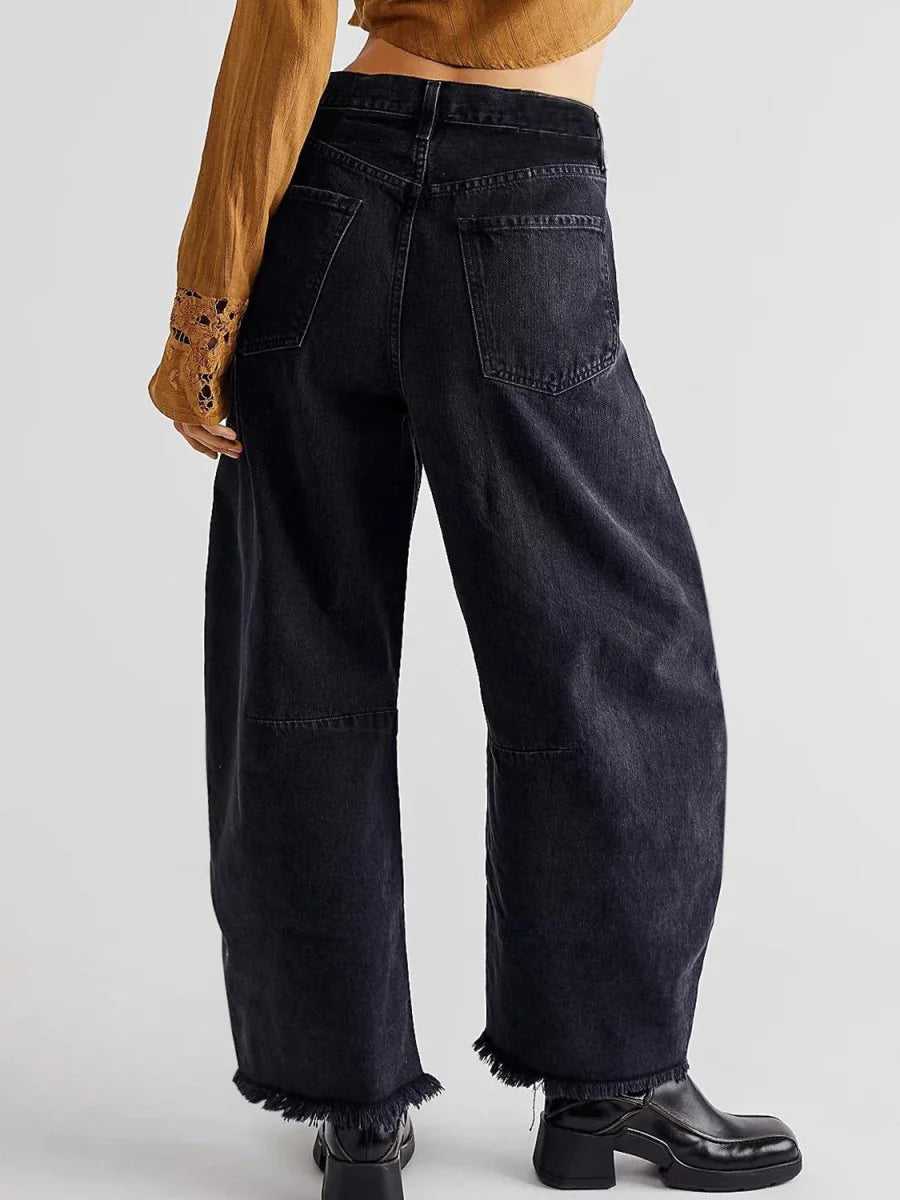 Black high-waisted wide-leg jeans with frayed hems, shown on a model from the back.