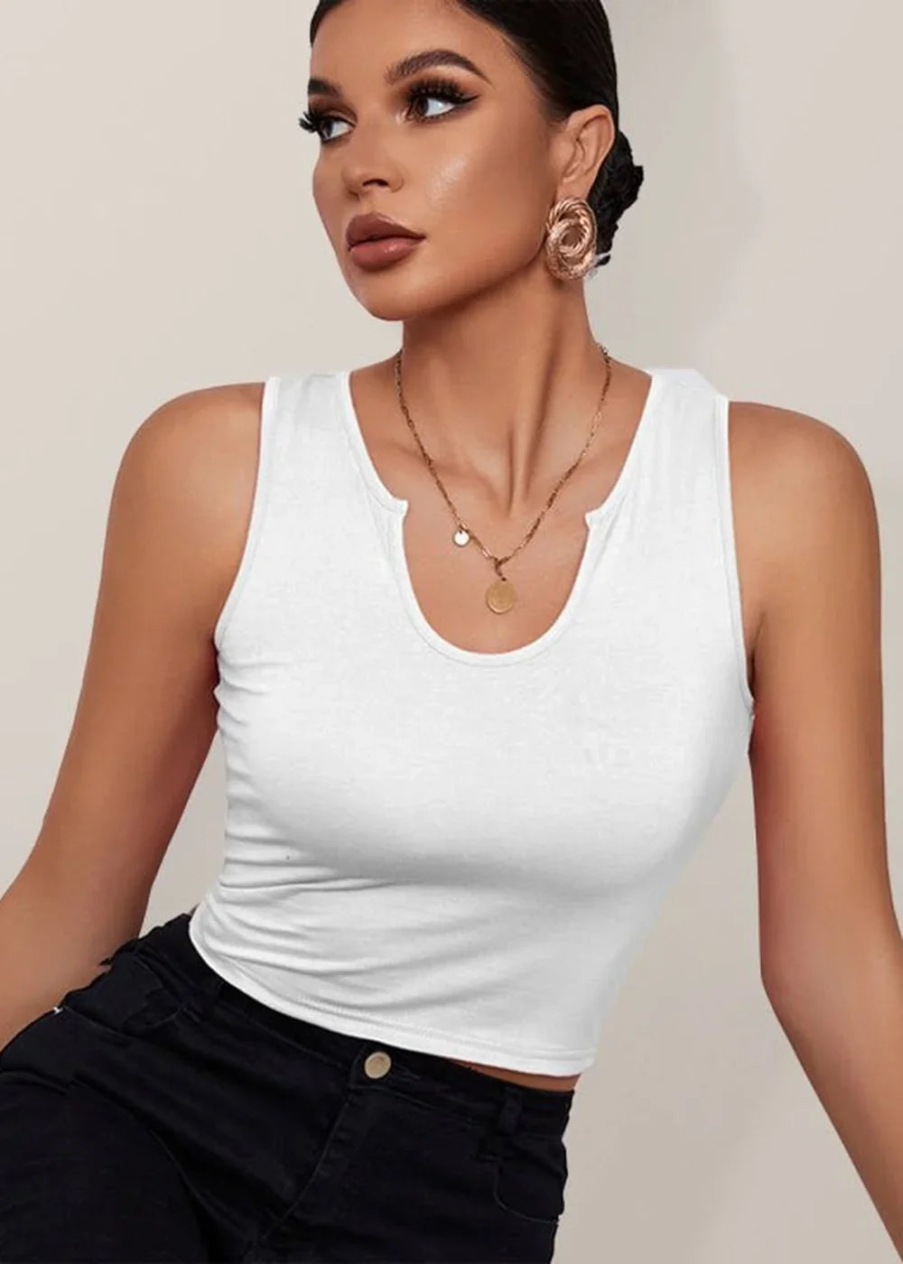 White ribbed tank top with a notched neckline and gold pendant necklace on model.