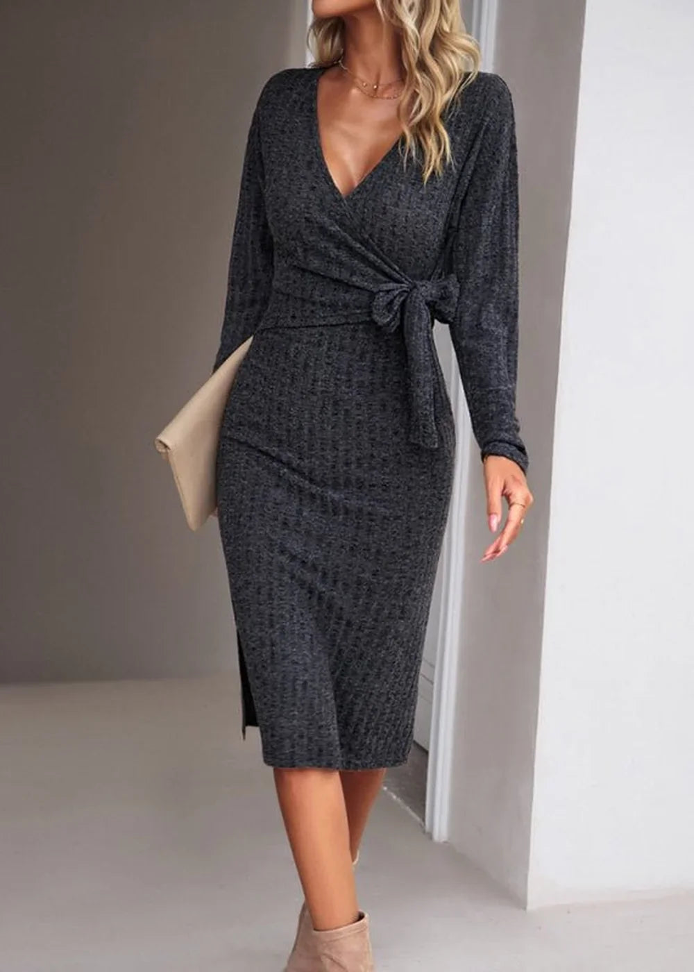 Dark gray ribbed wrap dress with tie waist and V-neck, shown on model with clutch and boots.
