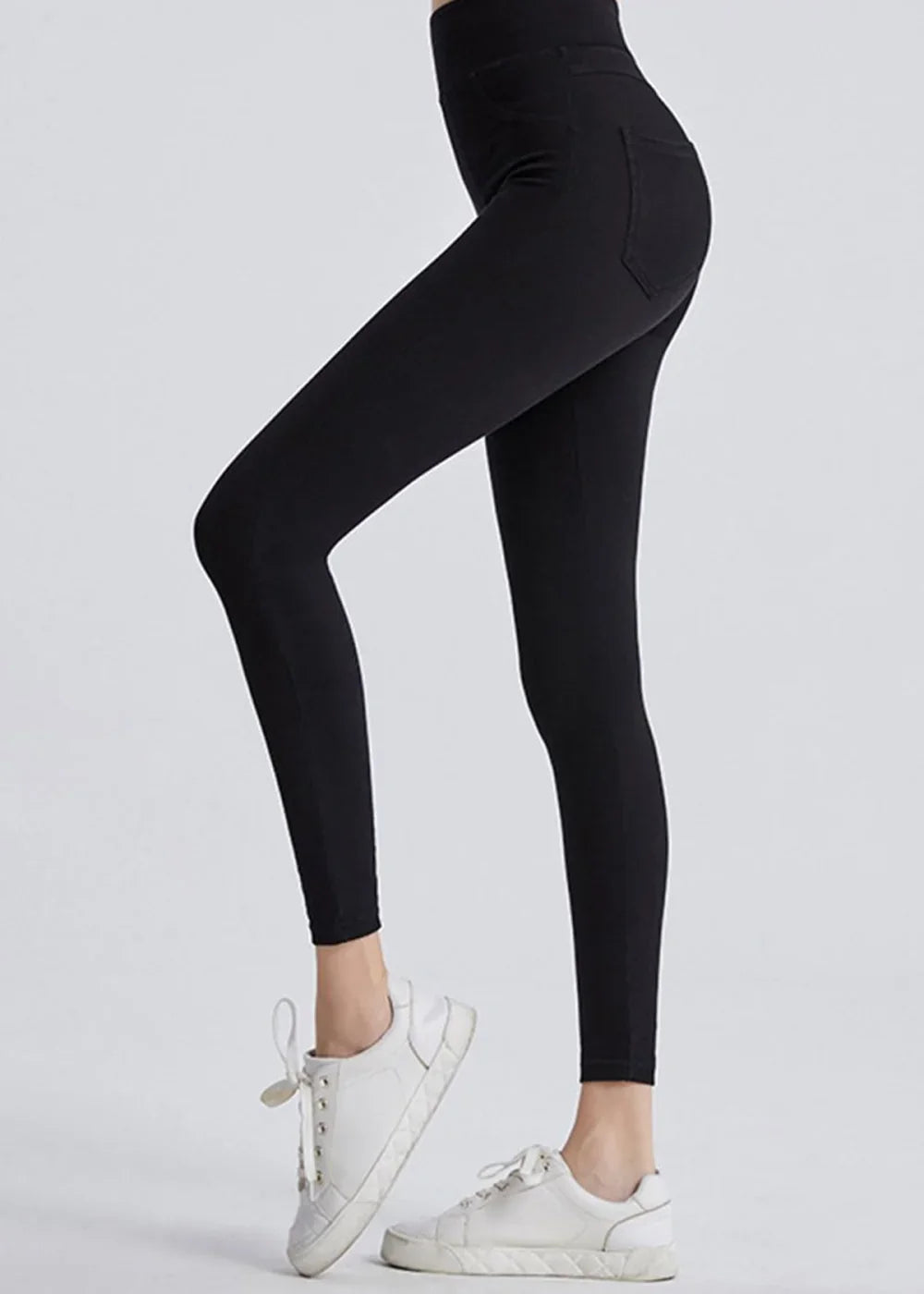 Black, form-fitting leggings with a subtle textured pattern and white sneakers.