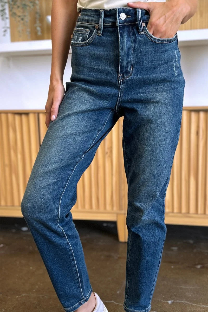 Medium wash distressed denim jeans with a regular fit on a model.
