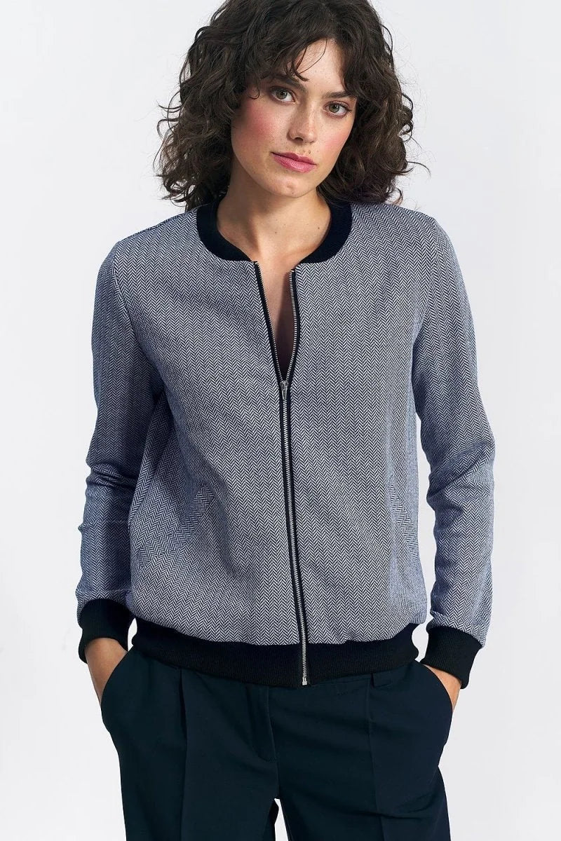 Navy and white herringbone bomber jacket with black trim and zipper detail on model.
