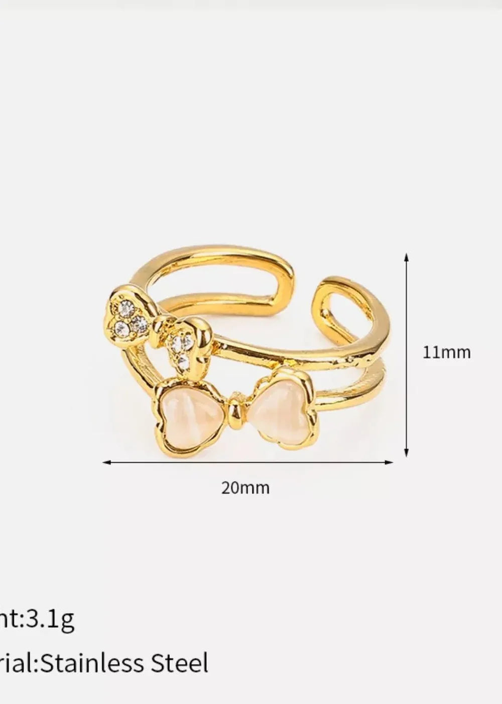 Gold double-band ring with two bow charms, one with rhinestones and the other with pink resin.