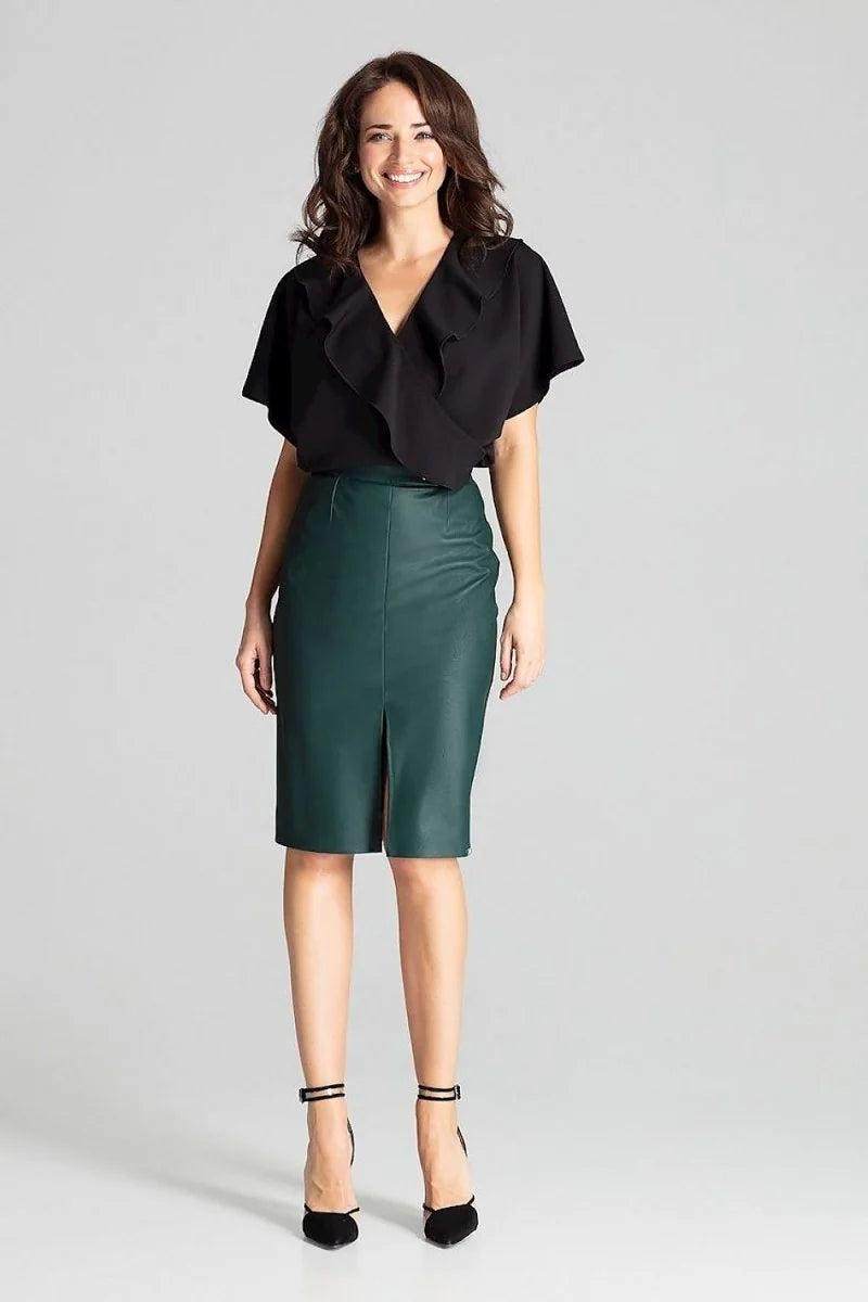 Woman in a black ruffled V-neck top and a dark green faux leather pencil skirt with a thigh slit.