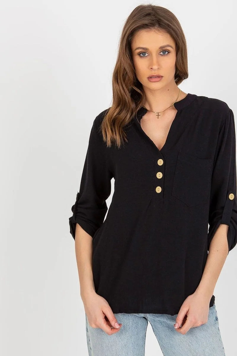 Black long-sleeve tunic with gold buttons and rolled cuffs on a model.