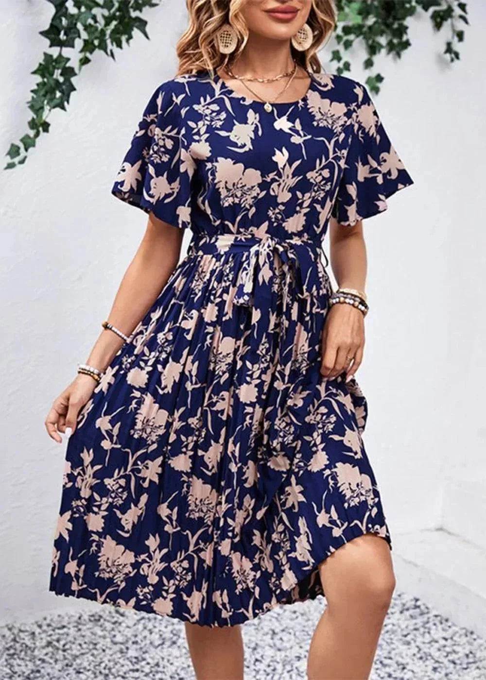 Navy blue floral print dress with flutter sleeves, belted waist, and pleated skirt.