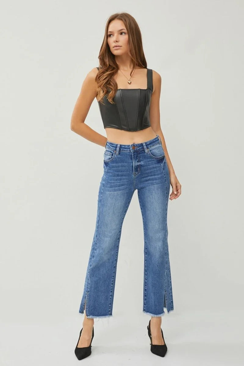 High-waisted, medium-wash denim jeans with frayed, slit hems and a flared leg.