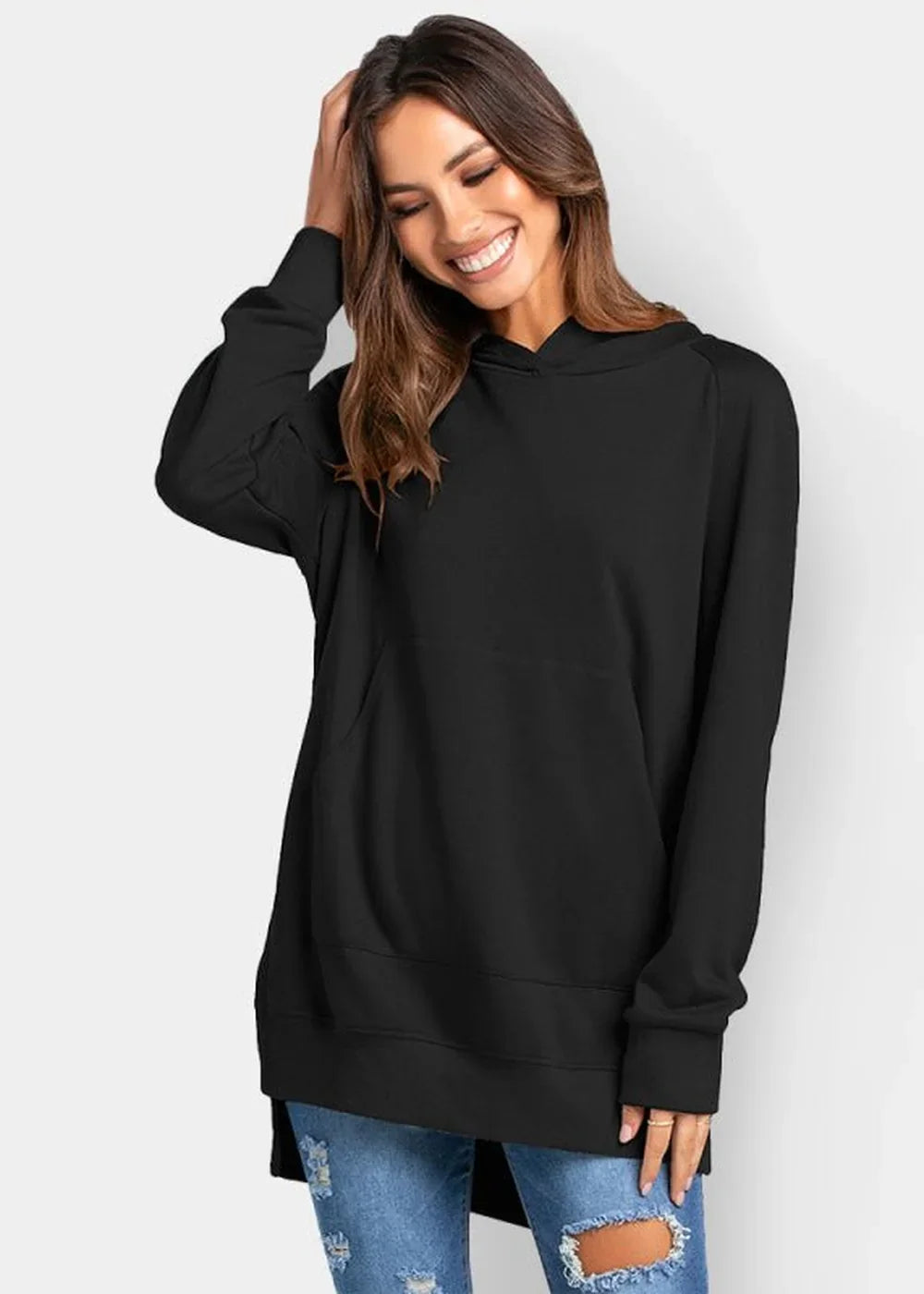 Black long-sleeve oversized hoodie with a kangaroo pocket, worn by a smiling model with ripped jeans.