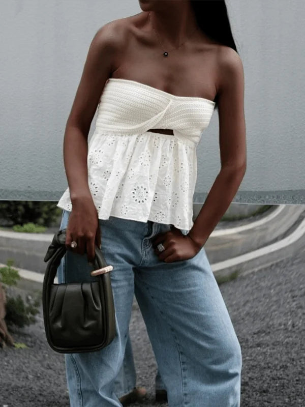 White eyelet strapless top with crochet bust detail and a cutout, paired with light wash wide-leg jeans.