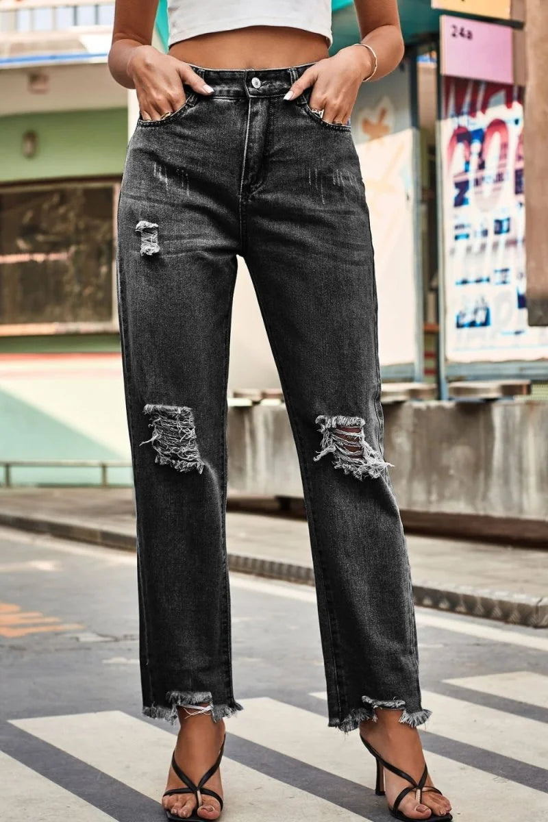 Distressed charcoal grey denim jeans with frayed hems and ripped knees.