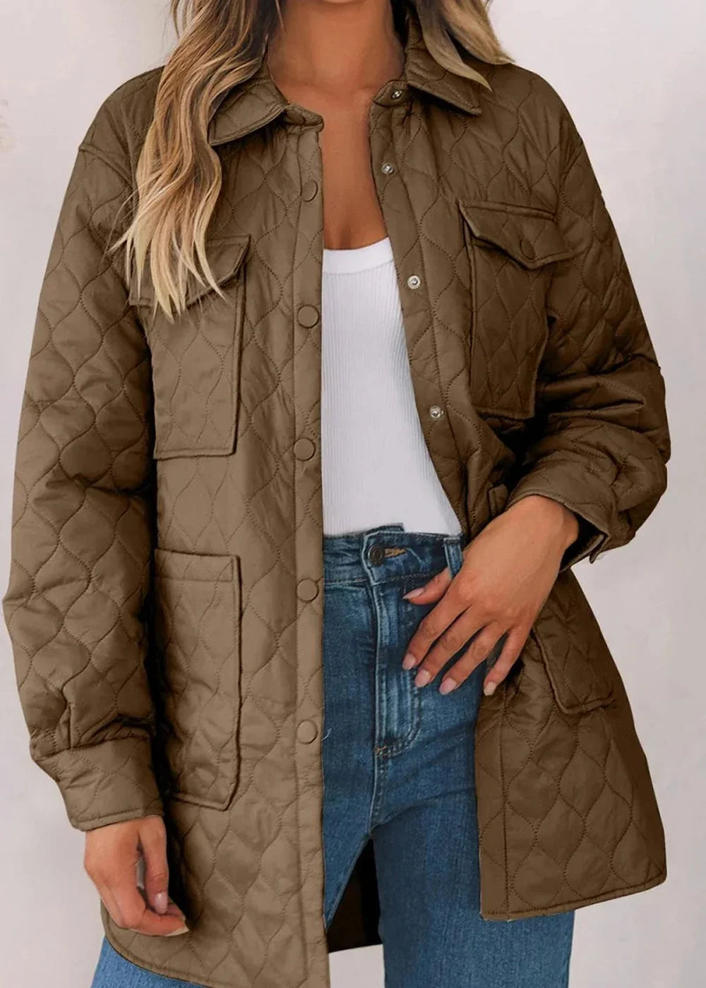 Quilted brown nylon jacket with snap buttons and chest pockets, worn over a white tank top and jeans.