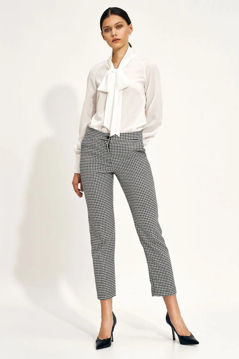 Black and white houndstooth patterned pants with a regular fit, on a model.
