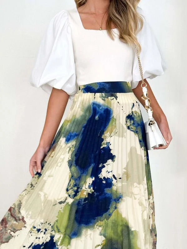 Pleated midi skirt with abstract blue, green, and beige watercolor print.
