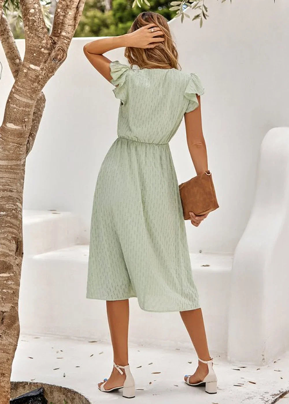 Light green cotton midi dress with a subtle textured pattern, flutter sleeves, and a cinched waist.