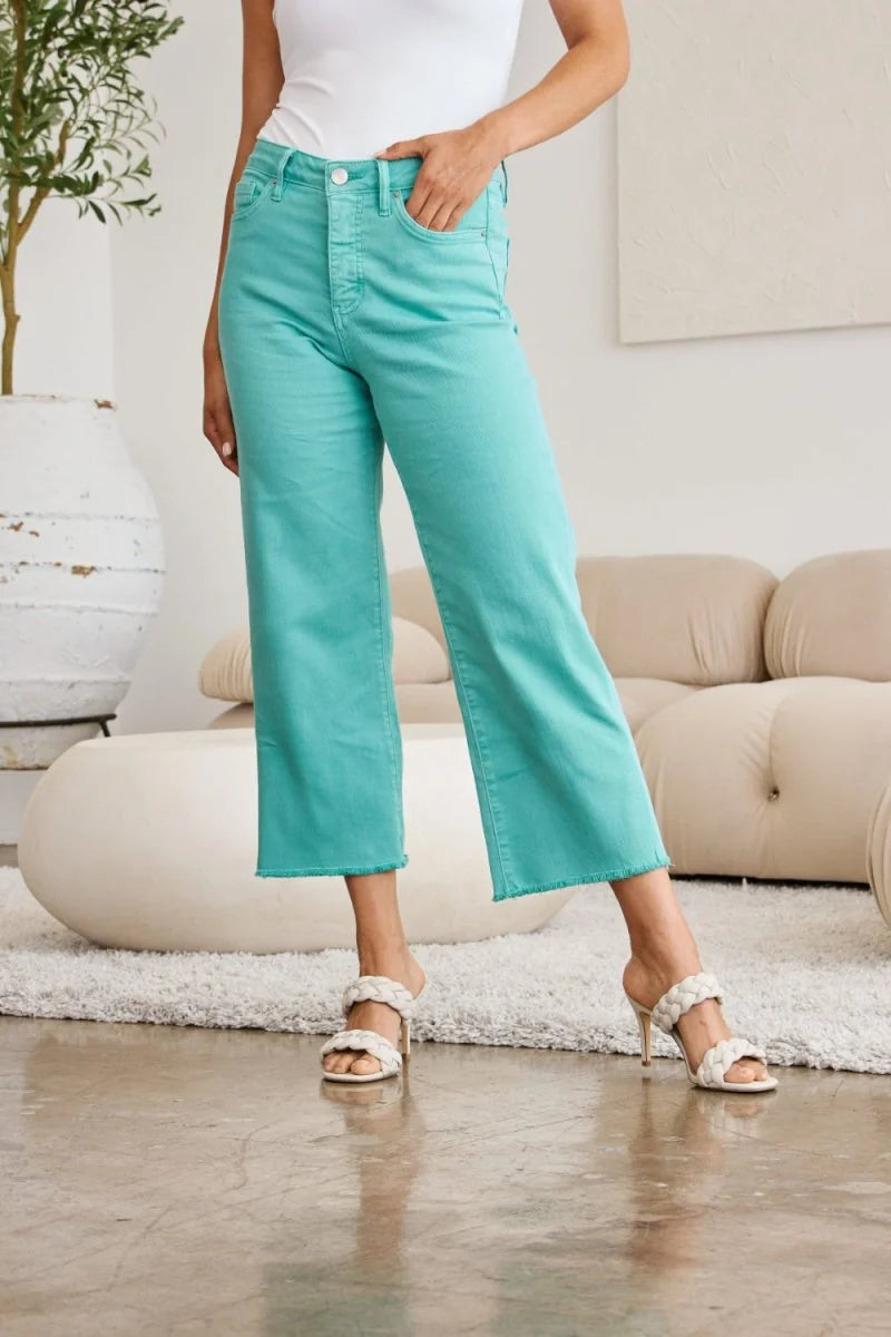 Aqua denim cropped wide-leg jeans with frayed hem, on model.