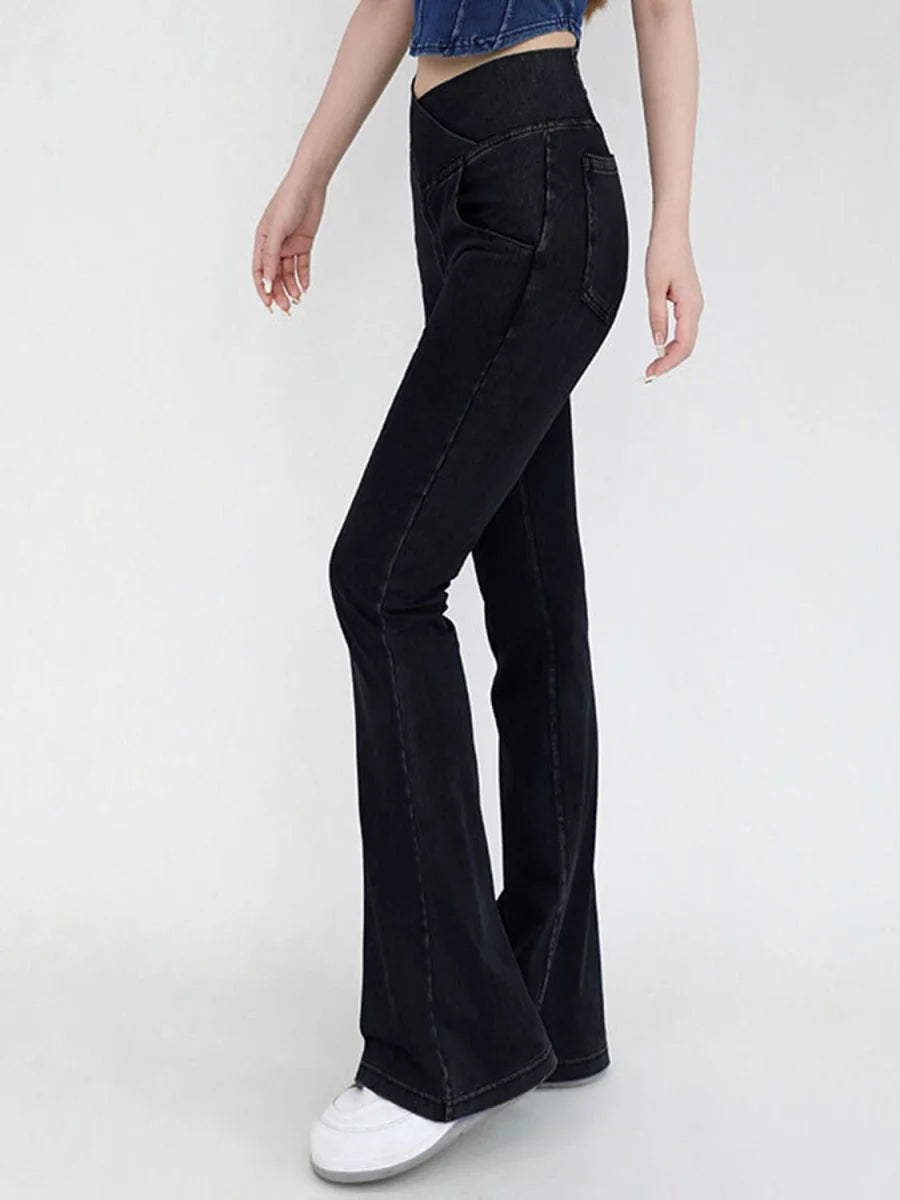 Black high-waisted flare jeans with a V-shaped waistline, on model.