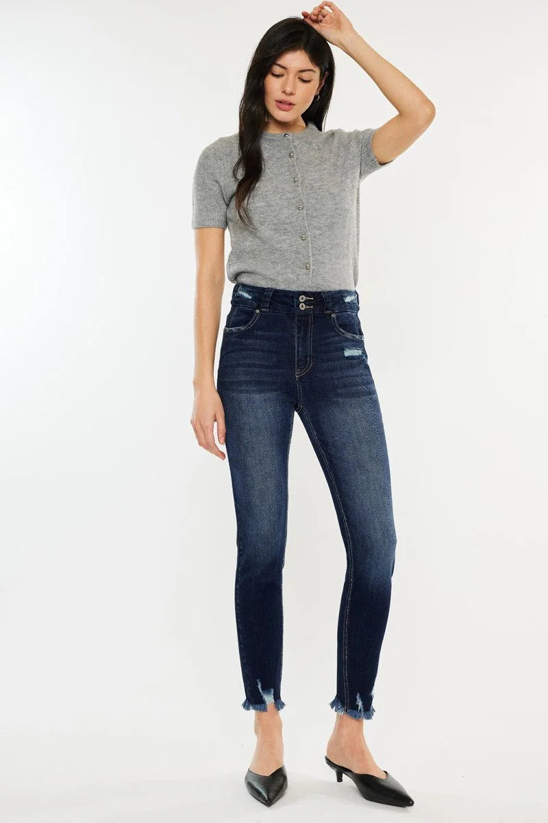 Dark wash, high-waisted denim jeans with frayed hems on model.