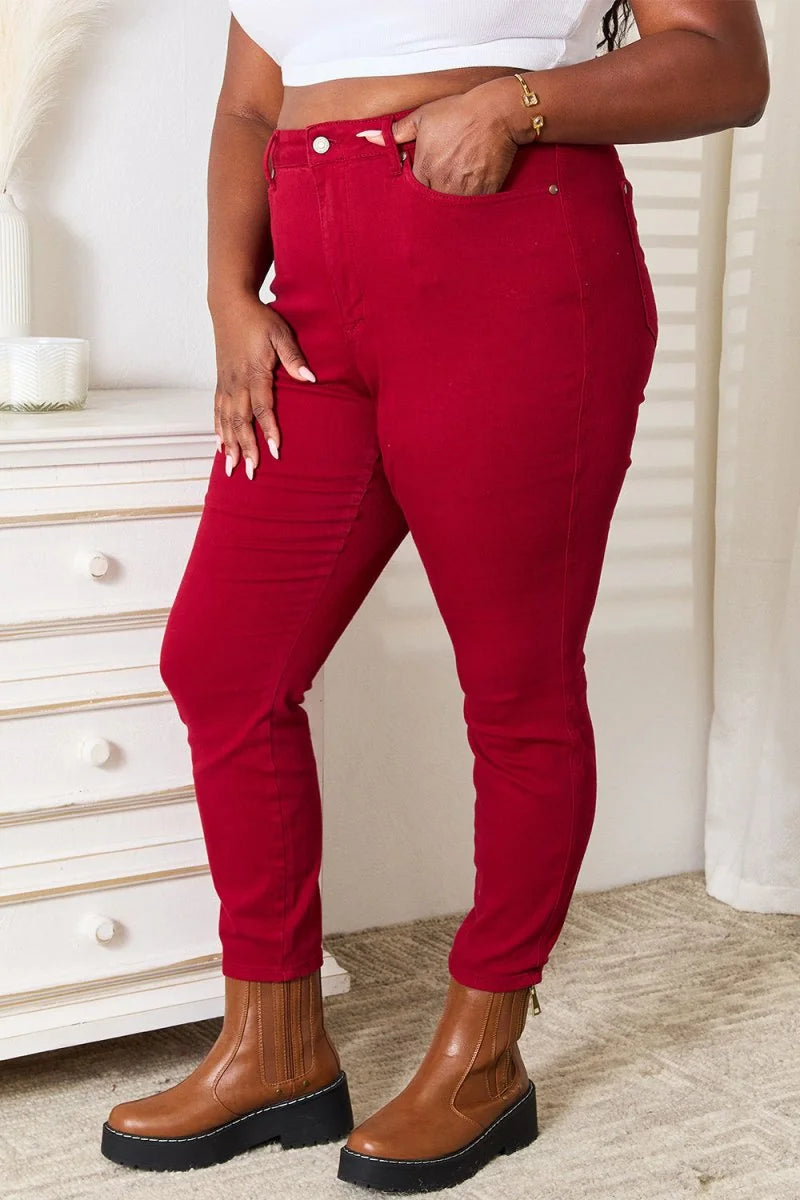Close-up of red skinny jeans with a gold bracelet and tan platform boots.