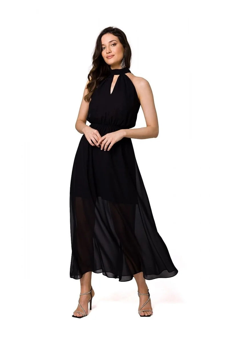 Black halter neck maxi dress with a sheer overlay and jeweled strap heels on a white background.