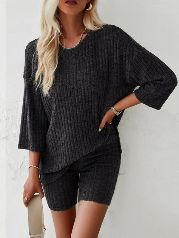 Dark grey ribbed knit loungewear set with a relaxed fit top and bike shorts.