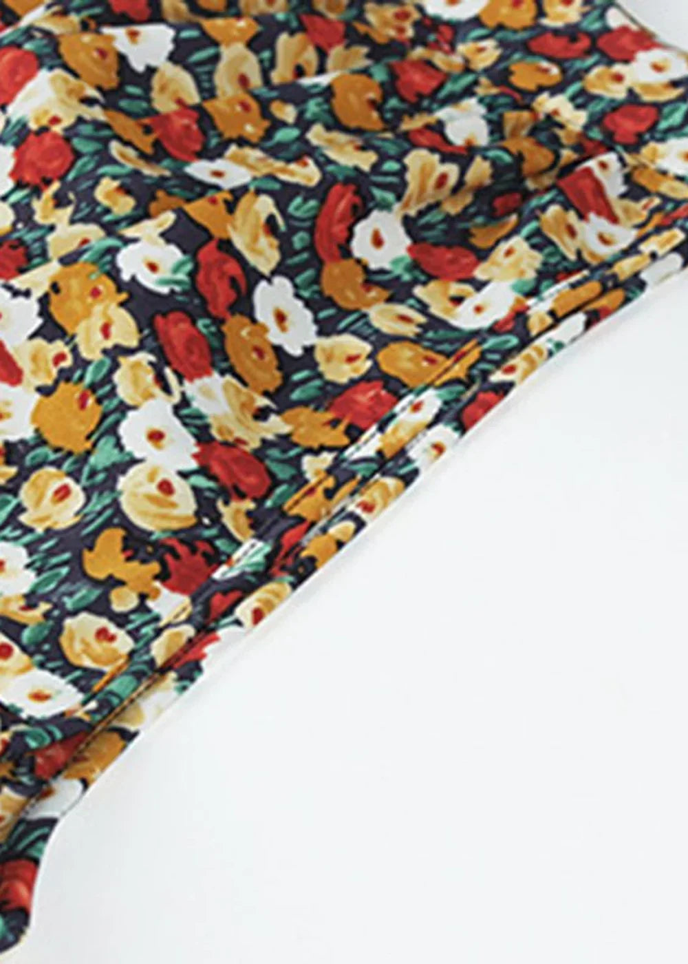 Close-up of a dark navy fabric with a vibrant floral print in red, yellow, and white.