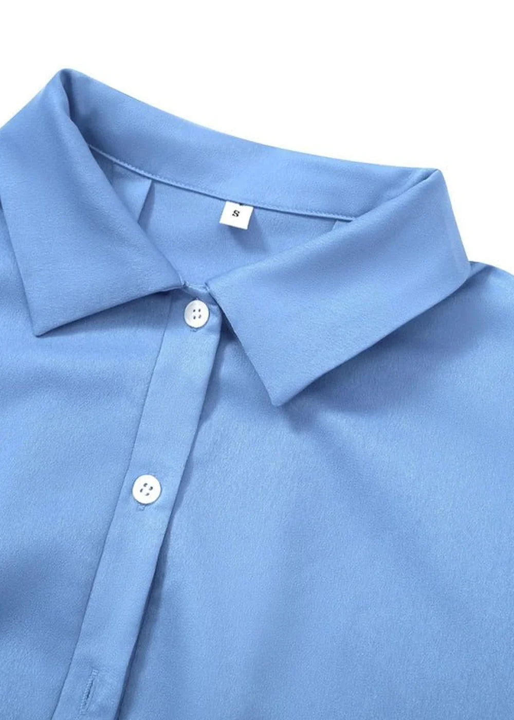 Close-up of a light blue collared shirt with white buttons and a size "S" tag.